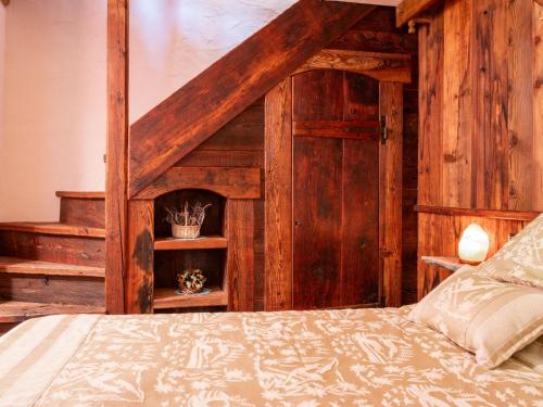 a bedroom with a bed and a wooden wall at Apartment Baita Baulin-2 by Interhome in Baulen