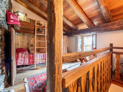 a staircase in a log cabin with wooden ceilings at Apartment Baita Baulin-2 by Interhome in Baulen