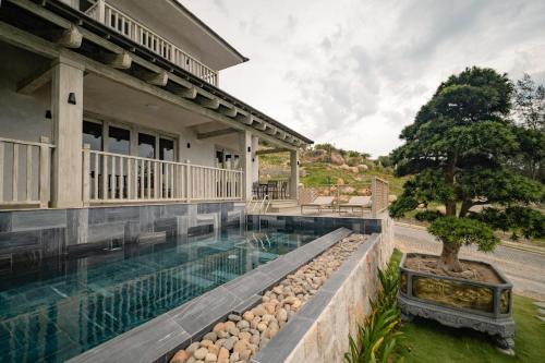 a swimming pool in front of a house at Crown Retreat Quy Nhon Resort in Quy Nhon
