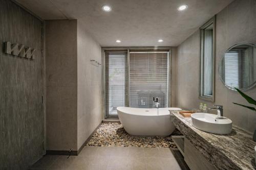 a bathroom with two sinks and a large tub at Crown Retreat Quy Nhon Resort in Quy Nhon