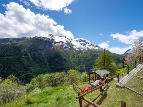 a person is sitting on a hill with a view of a mountain at Apartment Baita Baulin-2 by Interhome in Baulen