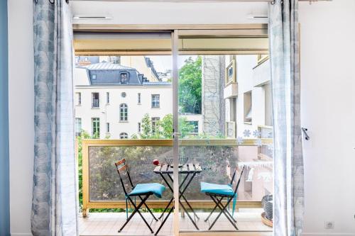 une chambre avec un balcon avec une table et des chaises dans l'établissement GuestReady - Chic & spacious living in Madeleine, à Paris