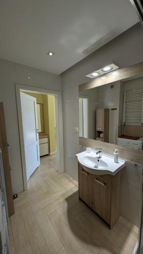 a bathroom with a sink and a large mirror at Apartamenty Morze Wygody in Międzywodzie
