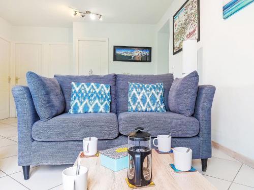 un canapé bleu dans un salon avec une table dans l'établissement Apartment Les gentianes by Interhome, à Saint-Gervais-les-Bains