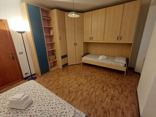 a small room with a bed and wooden cabinets at Casa Sinetta Como Lake in Acquaseria