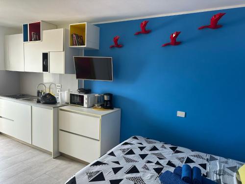 a bedroom with a blue wall with red birds on the wall at Estudio mondrian in Playa del Ingles