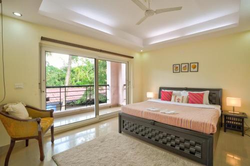 a bedroom with a bed and a large window at Luxury 3BHK Villa With Private Pool in Candolim in Nerul