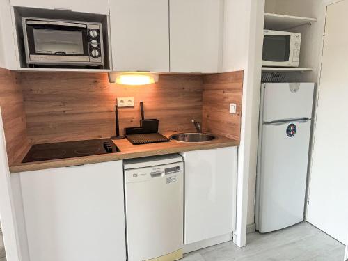 Il comprend une petite cuisine équipée d'une cuisinière et d'un réfrigérateur. dans l'établissement Studio Le Village - C1201 by Interhome, à Agay