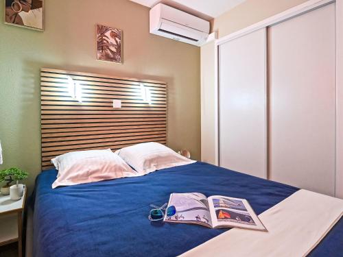 une chambre avec un lit avec deux livres et des verres dessus dans l'établissement Apartment Le Hameau - M4 333 by Interhome, à Agay