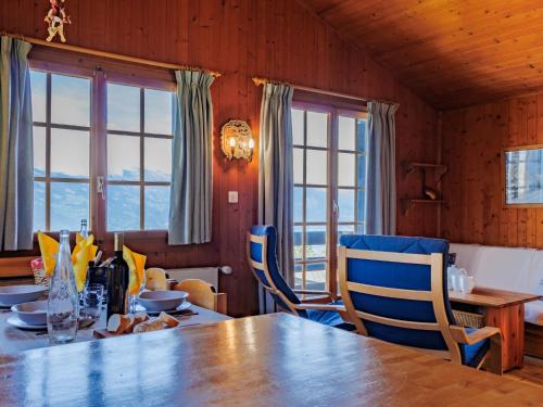 a dining room with a wooden table and blue chairs at Chalet Tsamandon 22 by Interhome in Nendaz