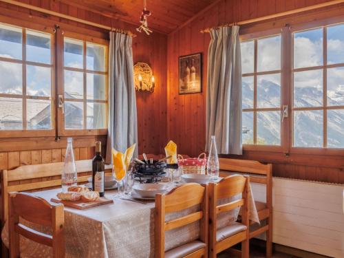 a dining room with a table and chairs and windows at Chalet Tsamandon 22 by Interhome in Nendaz