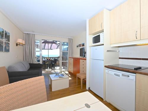 une cuisine et un salon avec un canapé et une table dans l'établissement Apartment Le Village - E1 309 by Interhome, à Agay