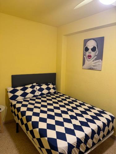 une chambre avec un lit à carreaux noirs et blancs dans l'établissement Habitación en la playa, à Valence