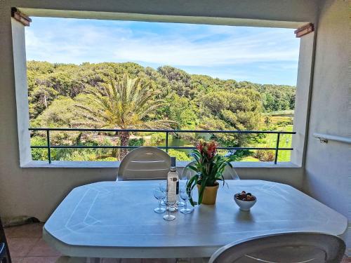 - une table avec des verres à vin et des fleurs sur le balcon dans l'établissement Apartment Les Rivages de Coudoulière-16 by Interhome, à Six-Fours-les-Plages