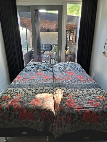 a bedroom with a bed with a comforter on it at Weerribben Wieden gastenverblijf in Wanneperveen
