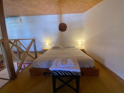 a bedroom with a bed with a table in it at Toti guest house 1 in São Tomé