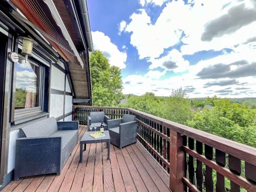 a balcony with chairs and a table on a house at Holiday Home Hänsel & Gretel im Kellerwald by Interhome in Frankenau