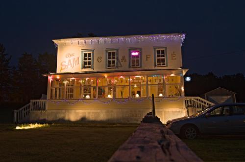 a building with christmas lights on it at night at Auberge du Café chez Sam in Baie-Sainte-Catherine