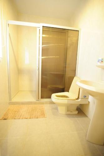e bagno con doccia, servizi igienici e lavandino. di Kenora Khaoyai Retreats - Private Pool Villa a Mu Si