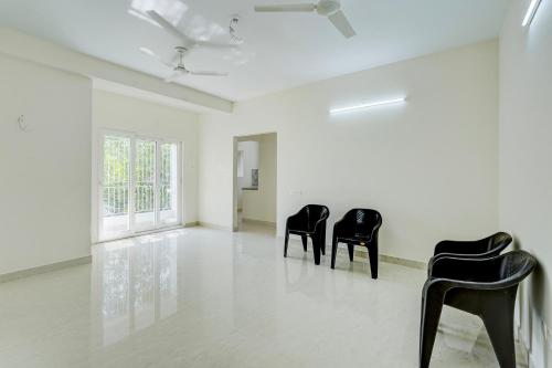 a white room with black chairs in it at Hotel O Eswar Guest House Padur in Chennai