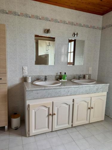 une salle de bain avec deux lavabos et un miroir dans l'établissement La Maison Jarrienne, à La Jarrie