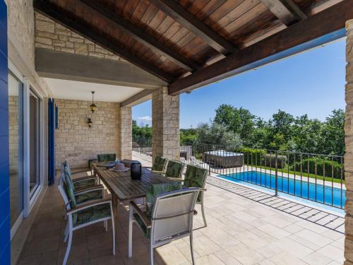 维斯尼安Villa Babudri by Interhome的一个带桌椅的露台和一个游泳池