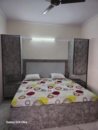 a bedroom with a bed with a colorful blanket at Shree Sai Stay in Gurgaon