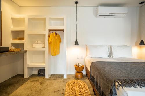 a bedroom with a bed and white walls and shelves at Nordisch- Chalés in Prea
