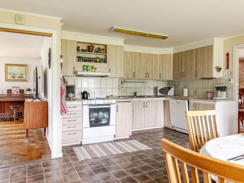 a kitchen with wooden cabinets and a table in a room at Holiday Home Störsjö Idyllen by Interhome in Slöinge