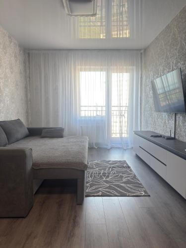 a living room with a bed and a flat screen tv at Жемчужина 59 in Odesa