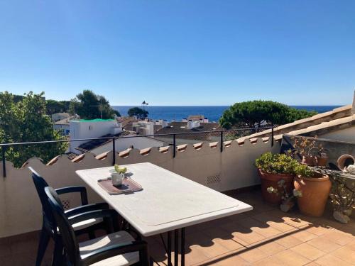 a table and chairs on a balcony with a view of the ocean at Confort al cor de Calella in Palafrugell