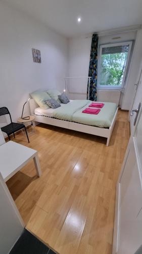 une chambre avec un lit et un parquet dans l'établissement Mulhouse gare, au bout du quai, à Mulhouse