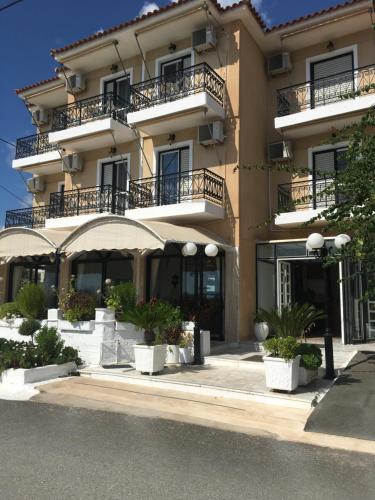 a large building with potted plants in front of it at Porto Finissia in Finikounta