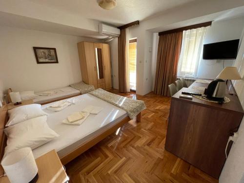 a hotel room with a large bed and a desk at Kukunesh Apartments in Ohrid