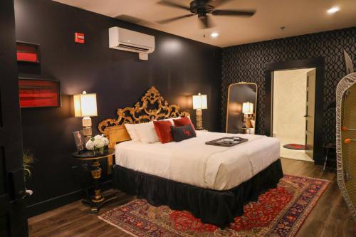 a bedroom with a large bed with a black wall at GunRunner Boutique Hotel in Florence