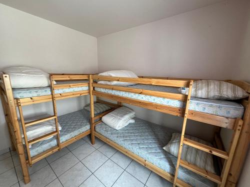 une chambre avec trois lits superposés dans une pièce dans l'établissement Maison Noirmoutier près du bois de la Chaise, à Noirmoutier-en-l'lle