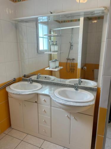 une salle de bain avec deux lavabos et un grand miroir dans l'établissement Maison Noirmoutier près du bois de la Chaise, à Noirmoutier-en-l'lle