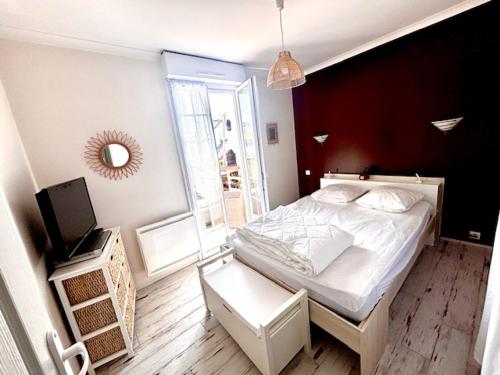 une chambre avec un lit blanc et une fenêtre dans l'établissement Maison, vue mer 50m plage, à Port-Bail-sur-Mer