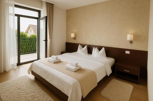 a bedroom with a large bed with two towels on it at Pensiunea Konfort in Baile Felix