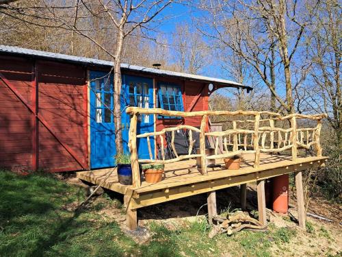a small house with a deck in front of it at Hilltop Train Carriage with a View in Machynlleth