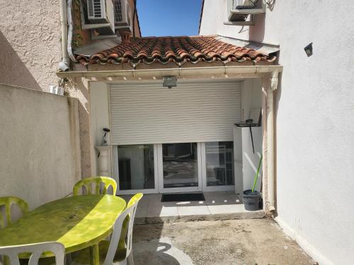 a patio with a table and chairs and a window at Bas de maison envoutant in Saint-Louis-du-Rhône