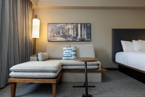 a hotel room with a couch and a bed at Courtyard by Marriott North Charleston Airport Coliseum in Charleston