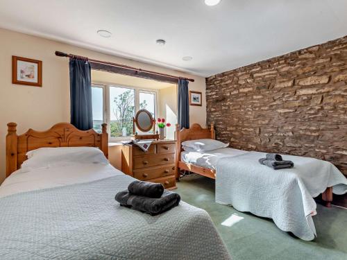 a bedroom with two beds and a stone wall at 2 Bed in Kirby Stephen SZ265 in Ravenstonedale