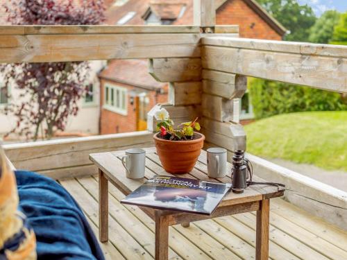 a table with a flower pot and a book on a porch at 2 Bed in Blandford Forum 61027 in Child Okeford