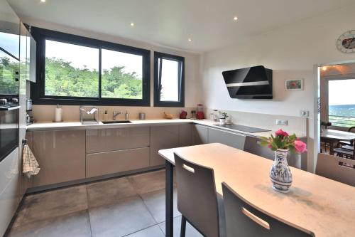une cuisine avec une table avec un vase de fleurs dessus dans l'établissement Havre familial standing Jardins Vue, à Marly-le-Roi