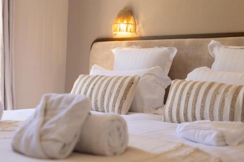 a bedroom with a bed with white sheets and pillows at Hôtel Lou Juan in Juan-les-Pins