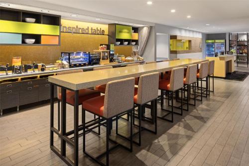 a kitchen with a bar with chairs and a counter at Home2 Suites by Hilton Roseville Minneapolis in Roseville