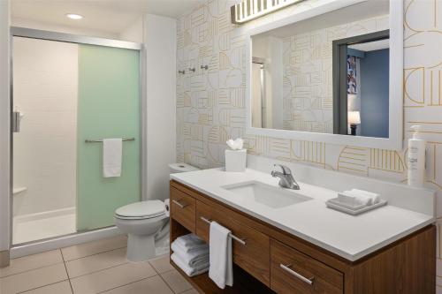 a bathroom with a sink and a toilet and a mirror at Home2 Suites by Hilton Roseville Minneapolis in Roseville
