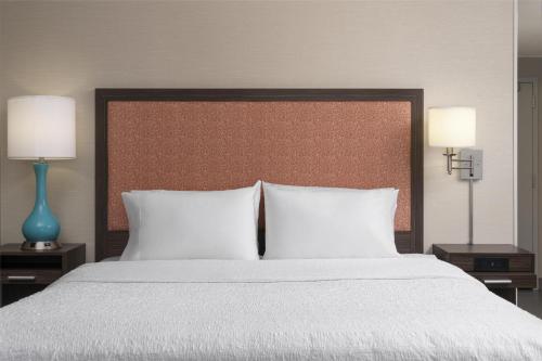 a bedroom with a large bed with two lamps at Hampton Inn & Suites Yonkers - Westchester in Yonkers