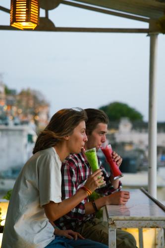 two people sitting at a table drinking drinks at Dreamyard Udaipur in Udaipur